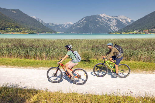 A couple explores the lakeshore in Maurach am Achensee by bike. 