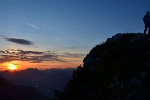 Wanderer genießen den Sonnenaufgang vom Gipfel des Ebner Joch.