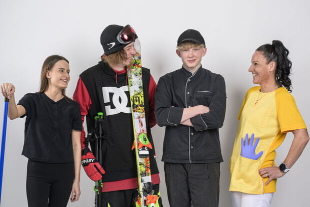 Mitarbeiter der Region Achensee Ein Zimmermädchen, ein Skifahrer, ein Kochlehrling & eine Pflegerin posieren vor der Kamera.