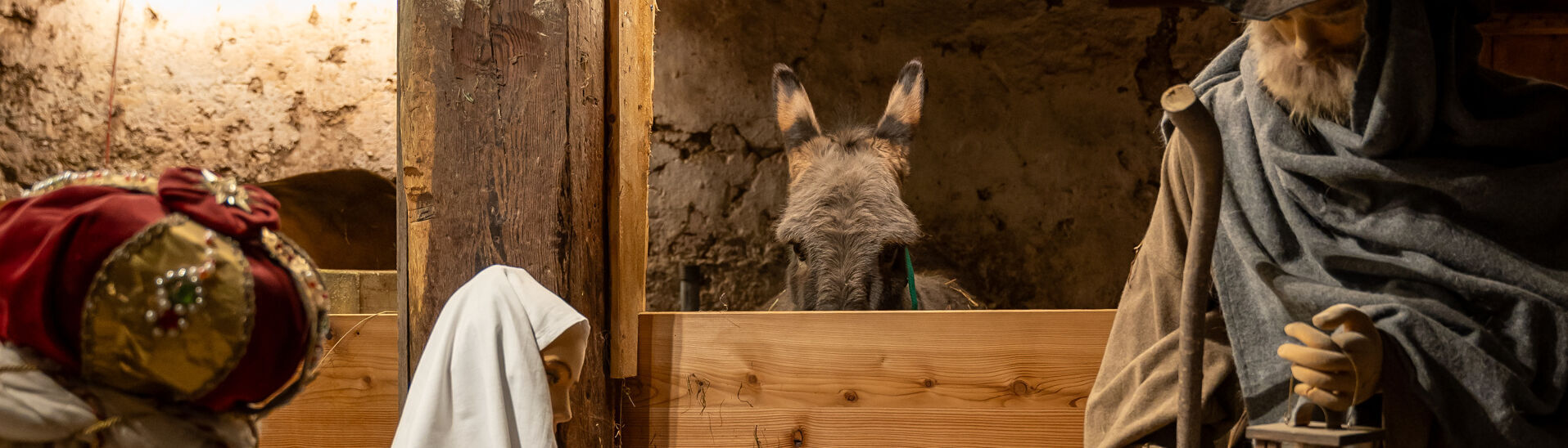 Die Krippe im Heimatmuseum Sixenhof Das Bild zeigt eine Weihnachtskrippe im Heimatmuseum Sixenhof in Achenkirch mit Figuren von Maria, Josef und einem Neugeborenen im Stroh. Im Hintergrund ist ein Esel zu sehen.