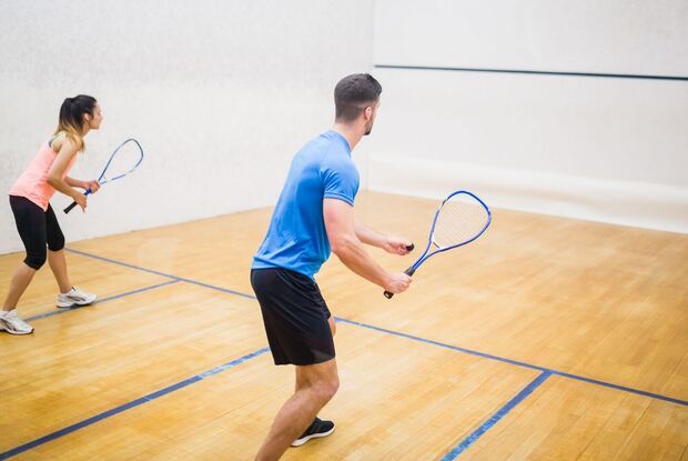 Zwei Squashspieler sind fokussiert auf das Spiel in einer Halle