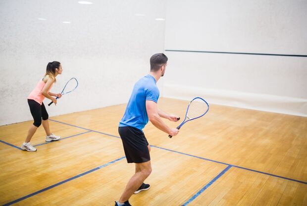 Zwei Squashspieler sind fokussiert auf das Spiel in einer Halle