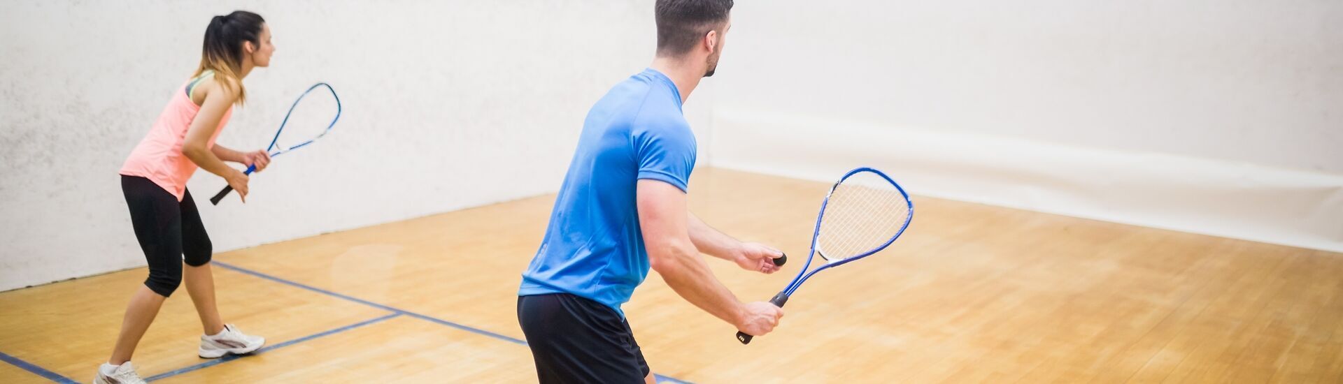 Zwei Squashspieler sind fokussiert auf das Spiel in einer Halle