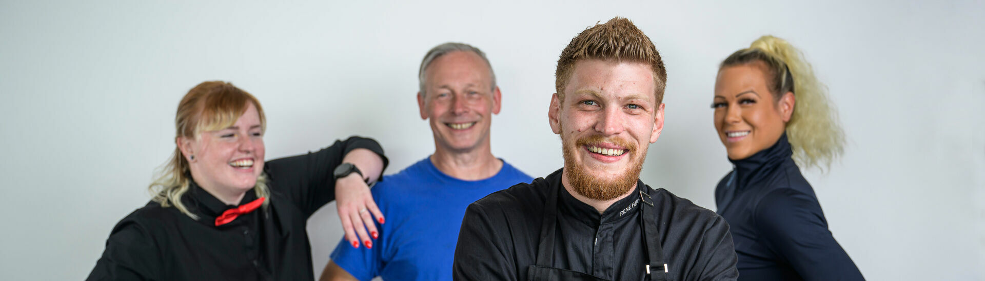 Group photo of a massage therapist, a riding instructor, a chef and a cable car staff member of the Achensee region.}