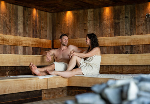 Ausflugsziele Ein Pärchen genießt den Aufguss im Wellnessbereich des Atoll Achensee.