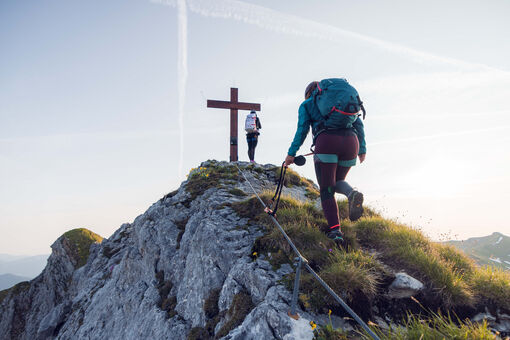 Two women who are enthusiastic about mountain sports enjoy the morning atmosphere at the Rosskopf via ferrata in the Rofan mountains.