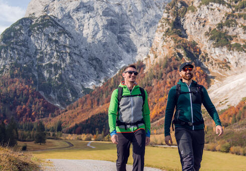 Wanderurlaub am Achensee Zwei Wanderer nutzen das herrliche Wetter und unternehmen eine Herbstwanderung durch das farbenfrohe Falzthurntal im Naturpark Karwendel. Im Bild ragt das Sonnjoch markant empor.