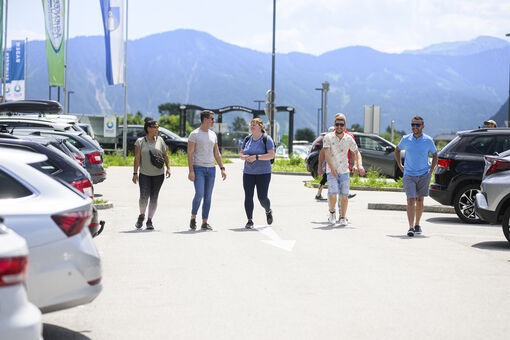A group of friends going to their cars in the car park of the Atoll Achensee. 