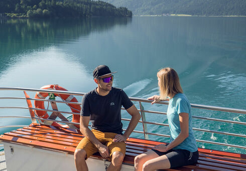 Ermäßigter Tarif für Erwachsene Ein Pärchen begibt sich auf einen Ausflug mit der Achenseeschifffahrt, um gemeinsam das Wasser und die malerische Landschaft in vollen Zügen zu genießen.
