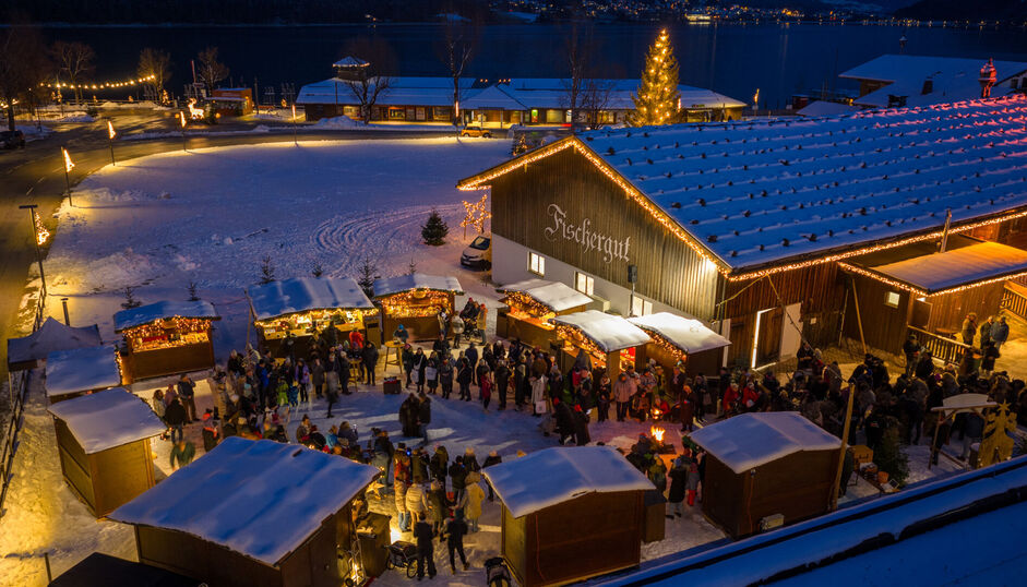 The Christmas market at Fischergut sparkles with lights and is surrounded by snow. Many visitors enjoy spending time there during the pre-Christmas season.