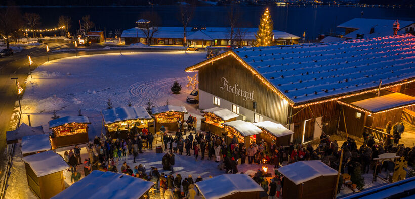 The Christmas market at Fischergut sparkles with lights and is surrounded by snow. Many visitors enjoy spending time there during the pre-Christmas season.