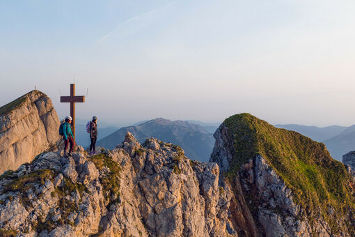 Zwei bergsportbegeisterte Frauen genießen die Morgenstimmung am Klettersteig Rosskopf im Rofangebirge.