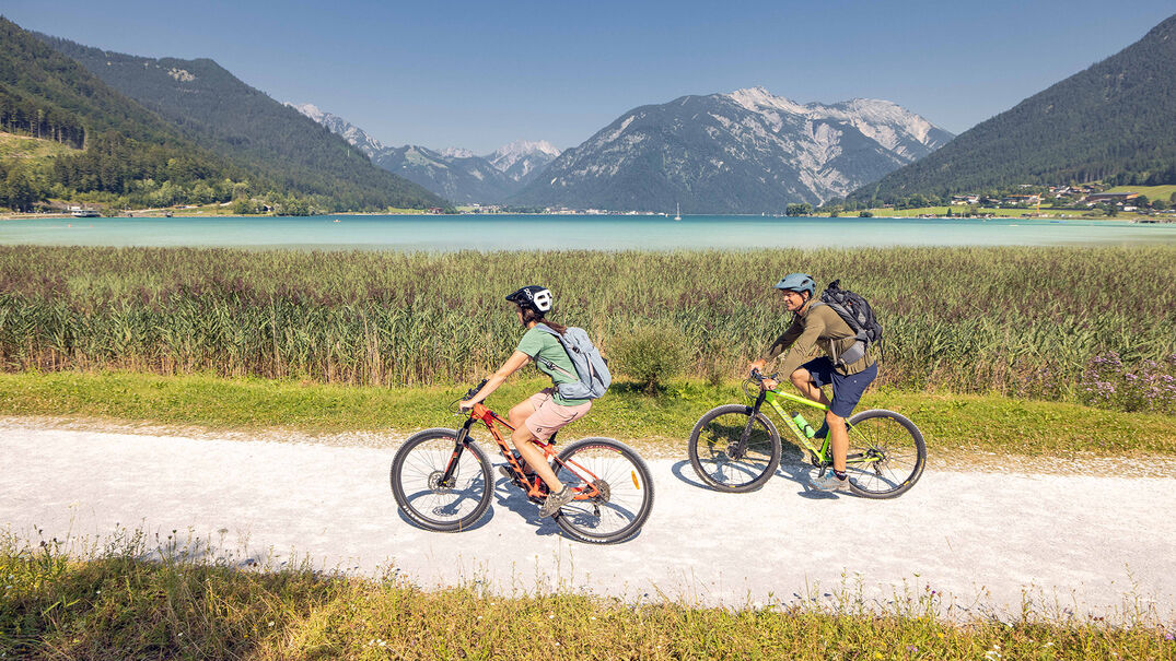 Ein Pärchen erkundet das Seeufer in Maurach am Achensee mit dem Bike.
