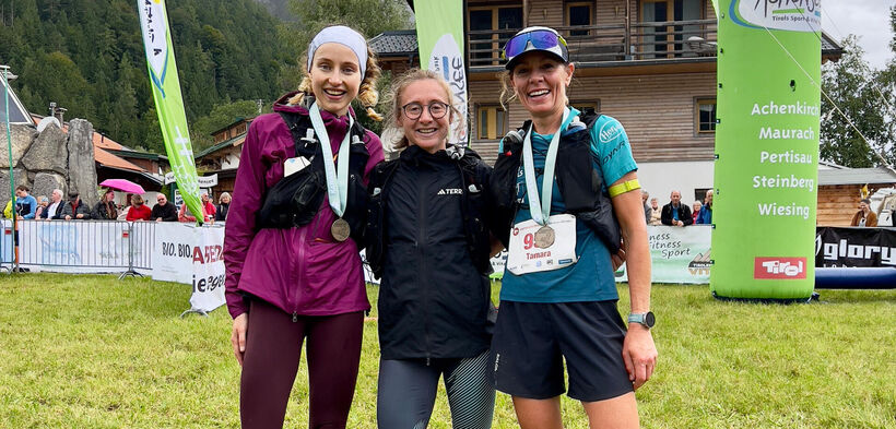 Die drei Siegerinnen des Karwendelmarschs 2025 lächeln zufrieden in die Kamera.