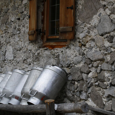 This photo captures large milk cans in front of the mountain hut in the Falzthurntal.
