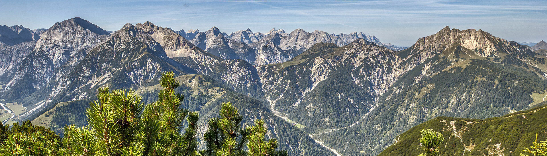 The mountain peaks of the Karwendel Nature Park tower upwards in the sunlight.
