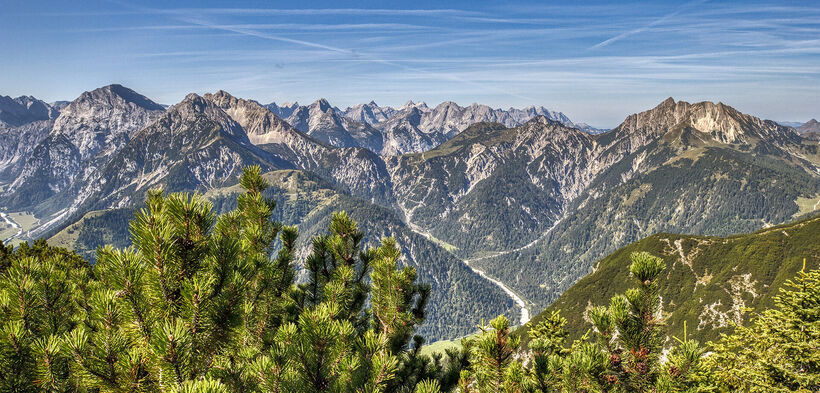 The mountain peaks of the Karwendel Nature Park tower upwards in the sunlight.