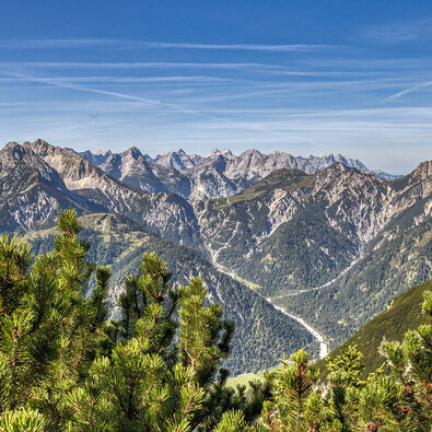 The mountain peaks of the Karwendel Nature Park tower upwards in the sunlight.