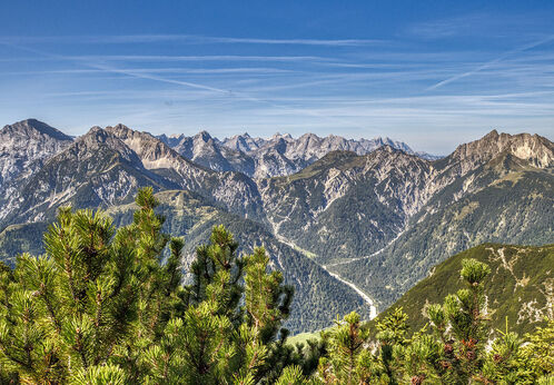 The mountain peaks of the Karwendel Nature Park tower upwards in the sunlight.