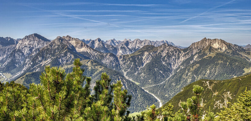 The mountain peaks of the Karwendel Nature Park tower upwards in the sunlight.