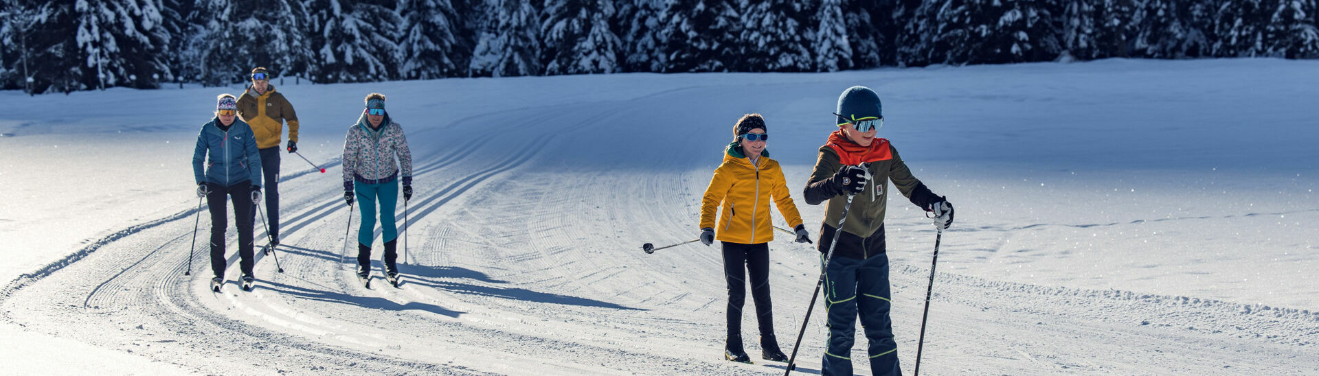 Eine Familie erlebt bei strahlendem Sonnenschein einen herrlichen Langlauftag in den Karwendeltälern.