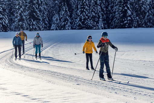 Eine Familie erlebt bei strahlendem Sonnenschein einen herrlichen Langlauftag in den Karwendeltälern.