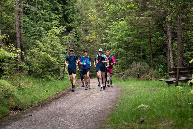 A group of runners out and about on gravel paths in the natural landscape of Lake Achensee.
