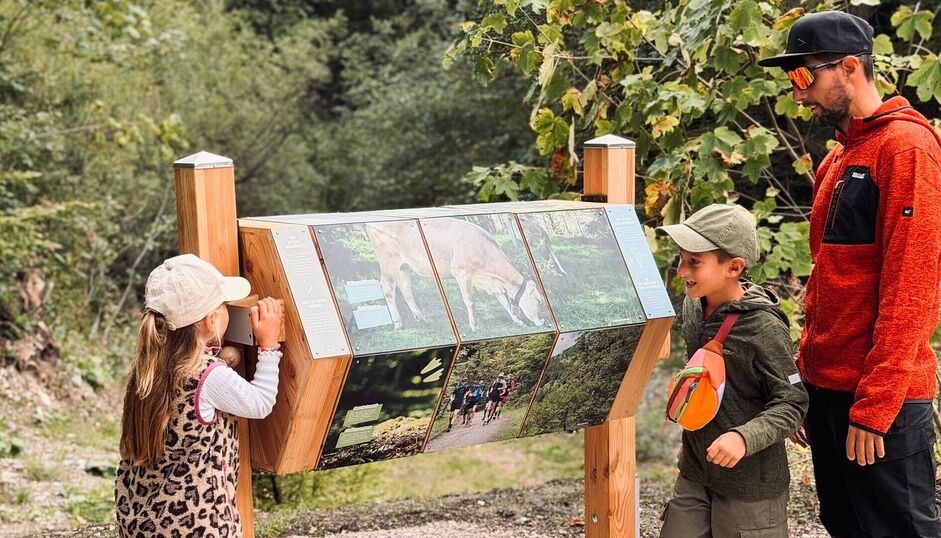 Eine Station des Entdeckerpfad Pertisau Zwei Kinder und ein Erwachsener stehen bei einer Station des Entdeckerpfad Pertisau.