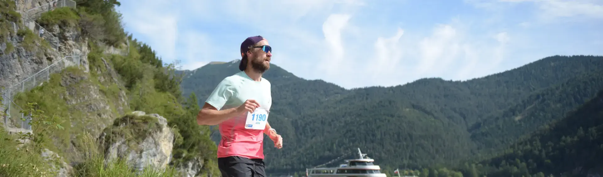 Ein Teilnehmer auf der Trail-Strecke des Achenseelaufs. Im Hintergrund ist die Achenseeschifffahrt zu sehen.