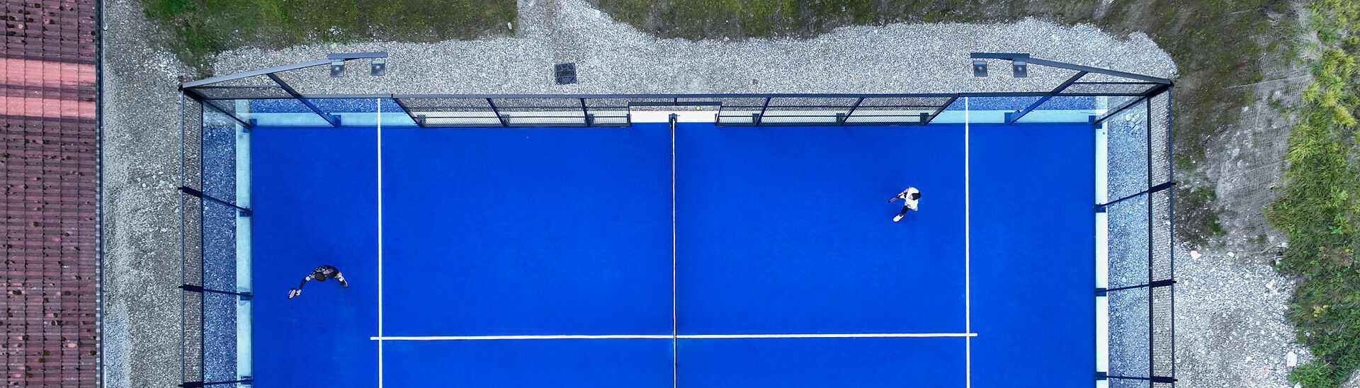 Luftaufnahme eines Padelplatzes am Achensee in Tirol mit vier Personen beim Padelspielen auf einem blauen Court.