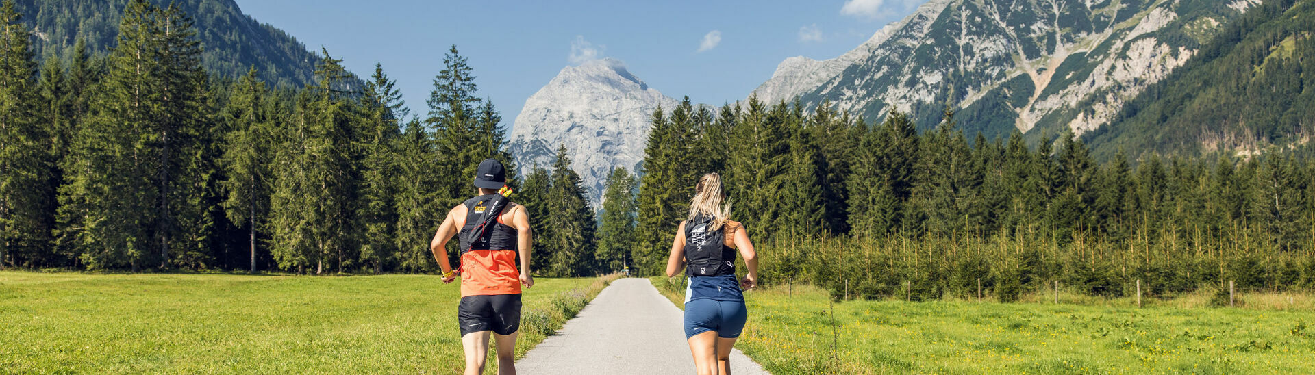 Zwei Läufer nutzen das schöne Wetter, um im Naturpark Karwendel mit Blick auf das Sonnjoch zu laufen.