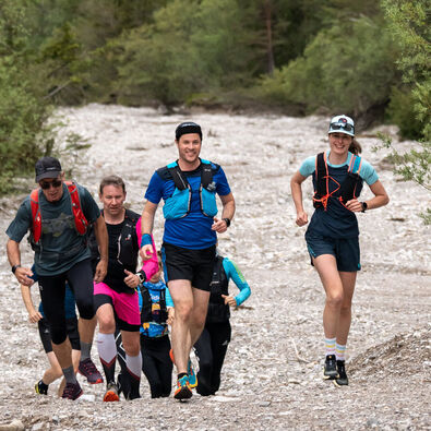 Eine Läufergruppe unterwegs auf Schotterwegen in der Naturlandschaft am Achensee.