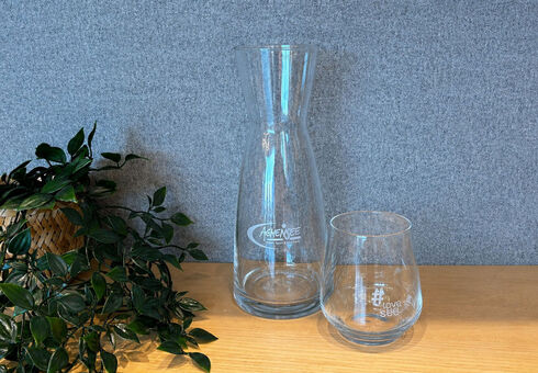 Ein Krug und ein Trinkglas mit einer Achensee Logo-Gravur