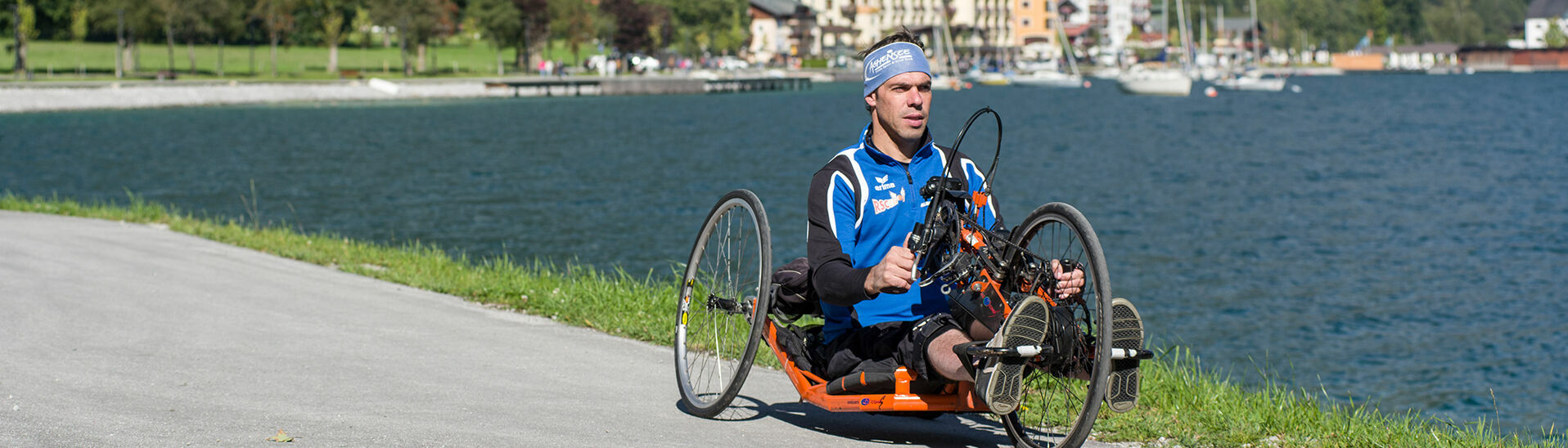 Handbike am Achensee Ein Mann radelt mit seinem Handbike die barrierefreie Route entlang des Achenseeufers in Pertisau.