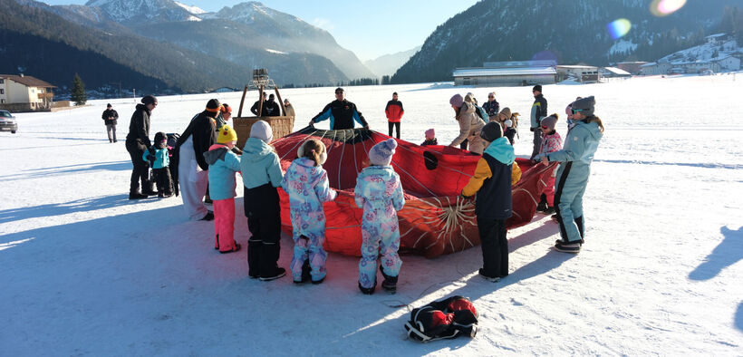 The programme of the Achensee Ballooning Days also includes an afternoon for children. Here, children stand around a hot air balloon.