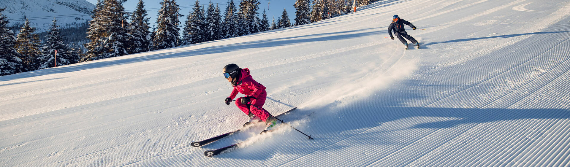 Bei strahlendem Wetter genießen zwei Skifahrer ihren Tag bei den Hochalmliften Christlum in Achenkirch am Achensee.