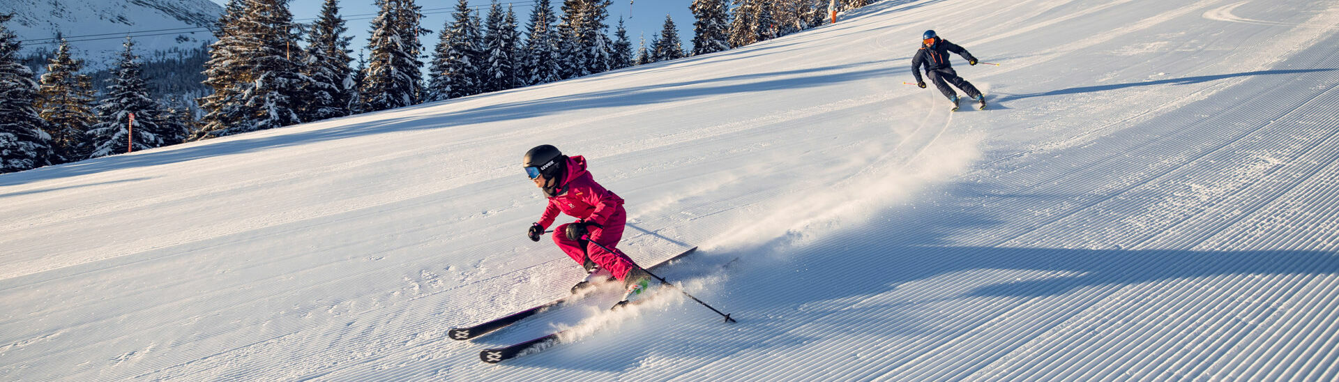 Bei strahlendem Wetter genießen zwei Skifahrer ihren Tag bei den Hochalmliften Christlum in Achenkirch am Achensee.