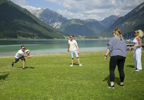 A group of friends playing volleyball at the lakeshore.