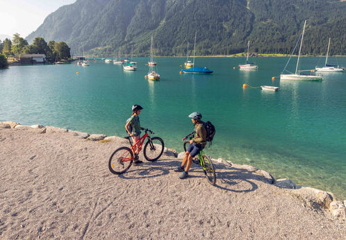 Ein Pärchen erkundet das Seeufer in Maurach am Achensee mit dem Bike.