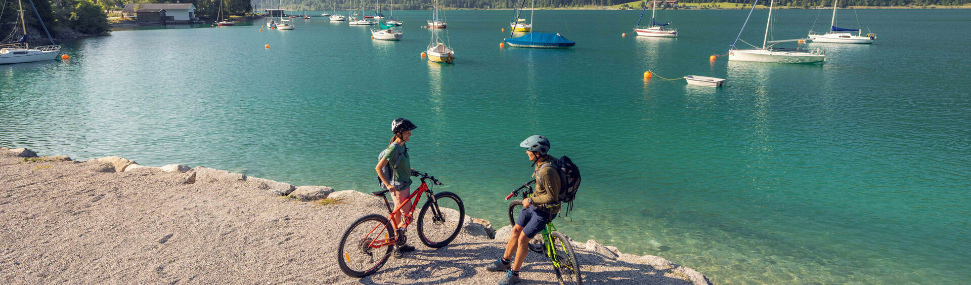 A couple explores the lakeshore in Maurach am Achensee by bike.