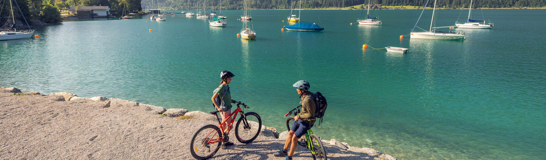 Ein Pärchen erkundet das Seeufer in Maurach am Achensee mit dem Bike.