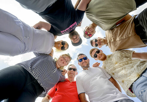 A team of men and women putting their heads together.