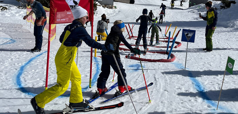 In glorious weather, several children complete an obstacle course on the slopes in Rofan.