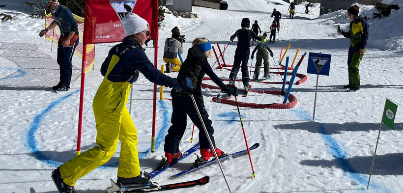 Bei herrlichem Wetter absolvieren mehrere Kinder einen Parcours auf der Piste im Rofan.
