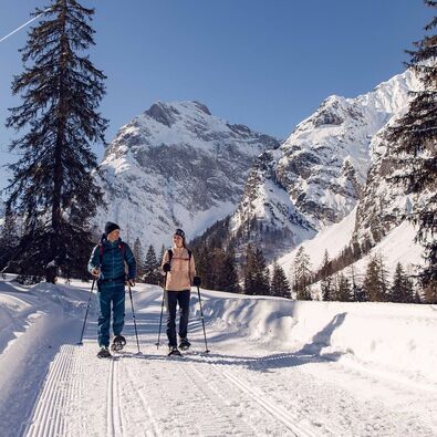 Two friends go on a snowshoe hike in glorious weather in the Falzthurntal valley in the Karwendel Nature Park.