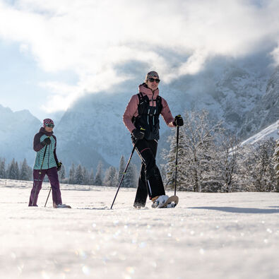 Two friends go on a snowshoe hike in glorious weather in the Falzthurntal valley in the Karwendel Nature Park.