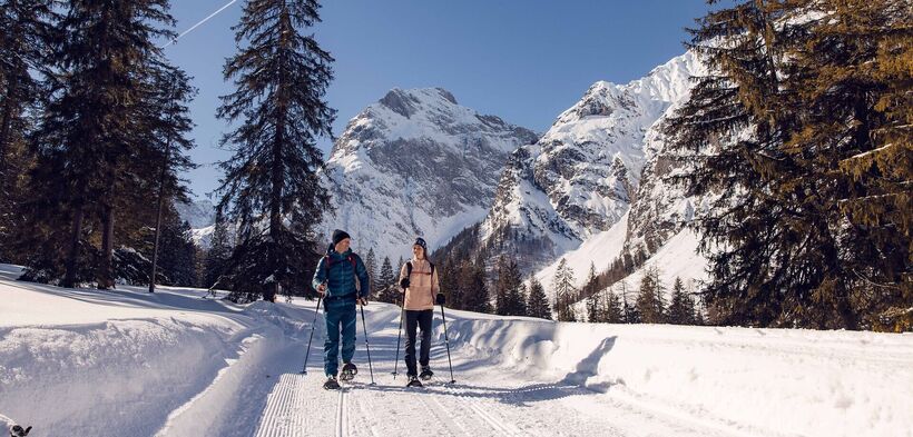 Two friends go on a snowshoe hike in glorious weather in the Falzthurntal valley in the Karwendel Nature Park.