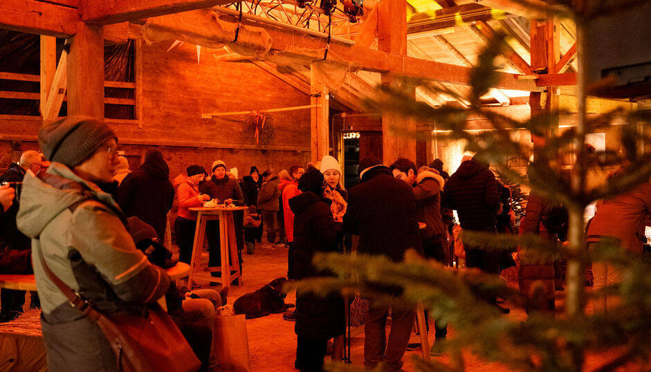 Drinnen im Fischergut treffen sich die Besucher, um sich aufzuwärmen. Beim Bergadvent im Fischergut in Pertisau treffen sich Besucher, um sich aufzuwärmen, Köstlichkeiten und Getränke zu genießen und der Musik zu lauschen. /// Visitors gather at the Fischergut to warm up, savour local delicacies, and enjoy the festive sounds of the Mountain Advent.
