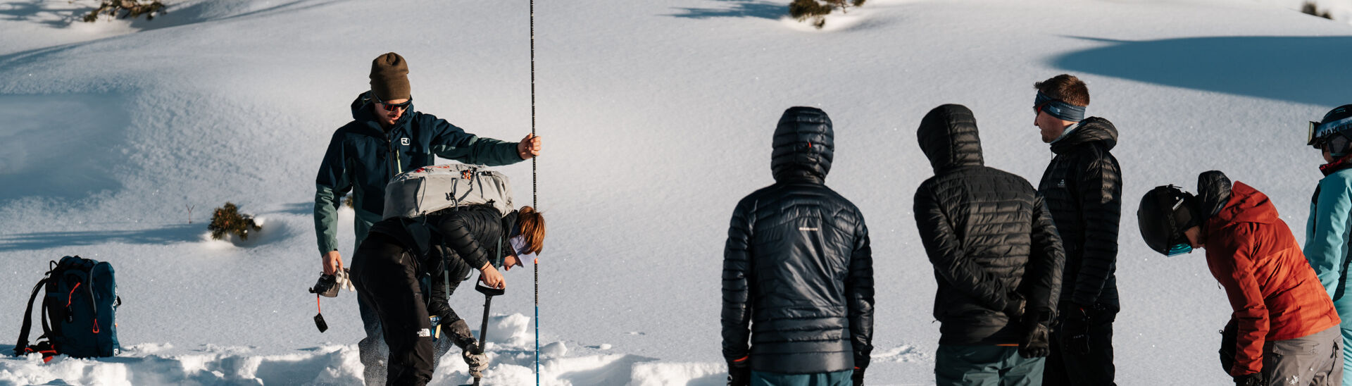 Participants of the Achensee ski tour camp learn how to use shovel and probe after an avalanche.