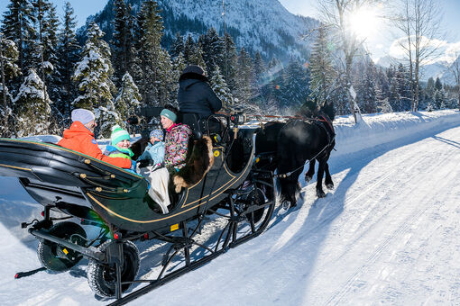 Eine Pferdekutschenfahrt in die tief verschneiten Karwendeltäler ist für die ganze Familie ein Erlebnis.